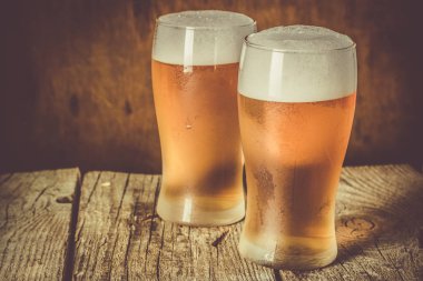 Rustik arka plan üzerinde soğuk bardağı bira