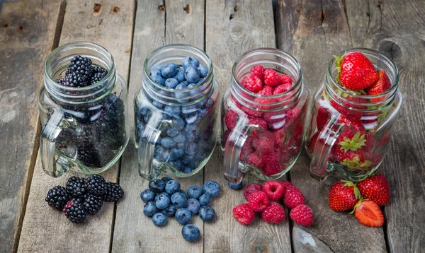 Berries in glass jars - homemade jam, smoothie, low fat dessert