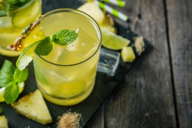 Rustik arka plan üzerinde ananas ve limon içecek