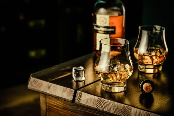 Whiskey in glazen met ijs op rustieke achtergrond — Stockfoto