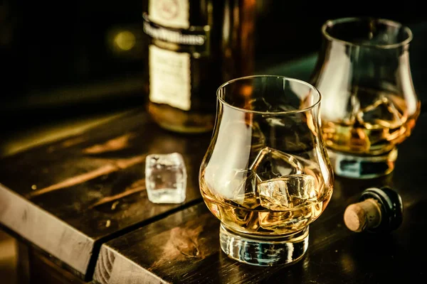 Whisky in Gläsern mit Eis auf rustikalem Hintergrund — Stockfoto