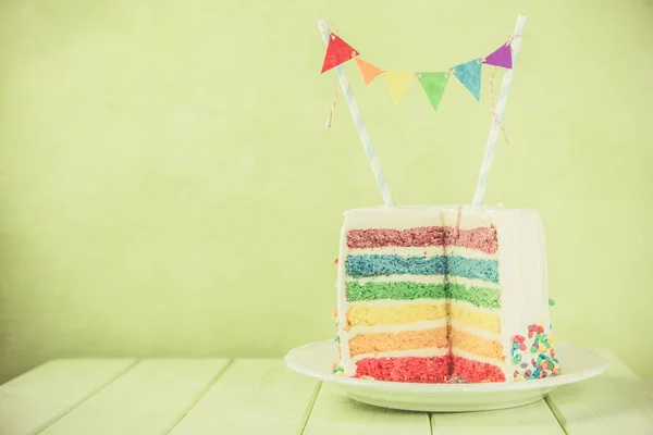 Fond d'anniversaire - gâteau arc-en-ciel rayé avec glaçage blanc — Photo