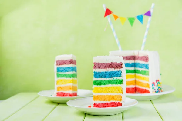 Fond d'anniversaire - gâteau arc-en-ciel rayé avec glaçage blanc — Photo