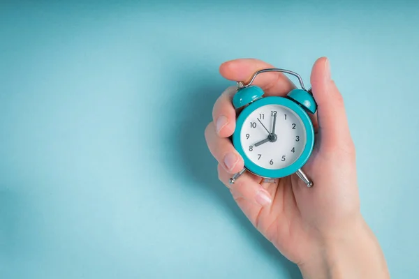 Female hand holding clock — Stock Photo, Image