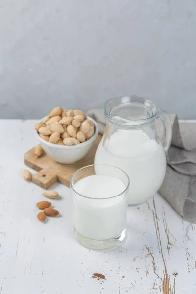 Mandelmilch im Glas und Glas auf Holzhintergrund — Stockfoto