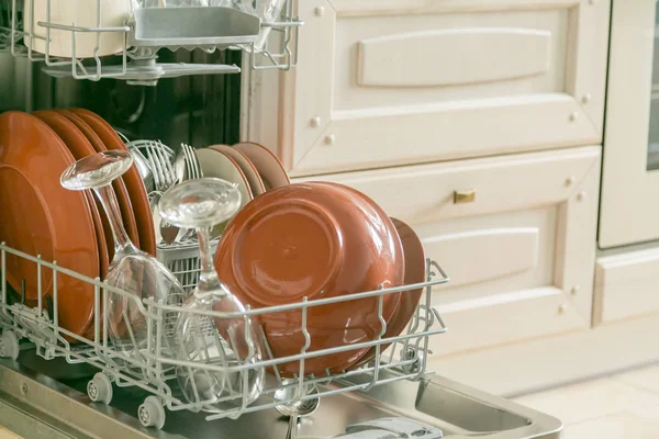 Lavavajillas completo con platos limpios en el fondo de la cocina —  Fotos de Stock