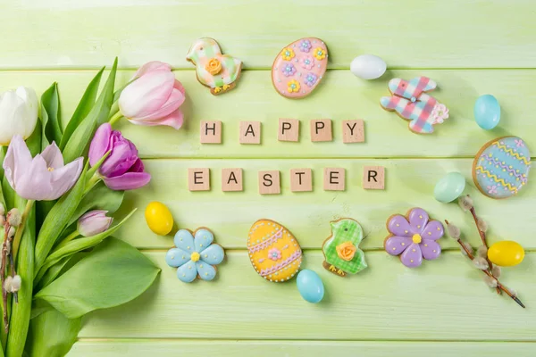 Easter concept - cookies with flowers on green wood background — Stock Photo, Image