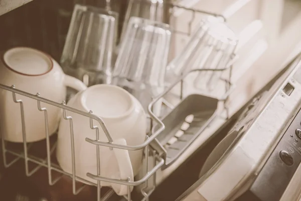 Посудомийна машина повна чистого посуду на кухонному фоні — стокове фото