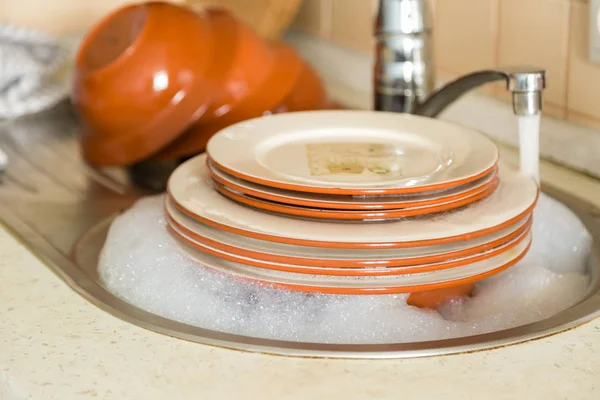 Dishes in the sink with kitchen background
