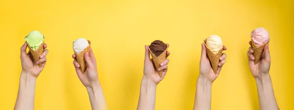 Руки, що тримають морозиво в конусах — стокове фото