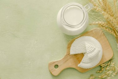 Shavuot kavramı - süt ürünleri ve buğday yeşil ahşap zemin üzerine