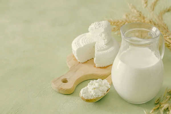 Shavuot concept - Milchprodukte und Weizen auf grünem Holz Hintergrund — Stockfoto