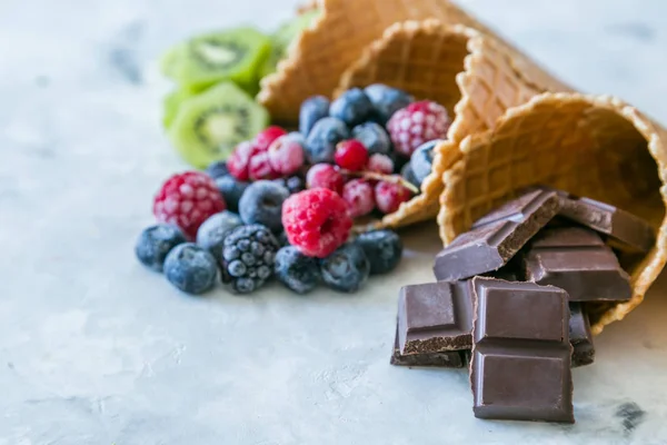 Здоровая диета - фрукты и замороженные ягоды в рожках мороженого на деревенском фоне — стоковое фото