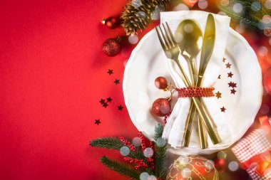 Kırmızı arkaplanda Noel sofra takımı ve dekorasyonları