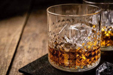 Ahşap arka planda gözlüklü viski.