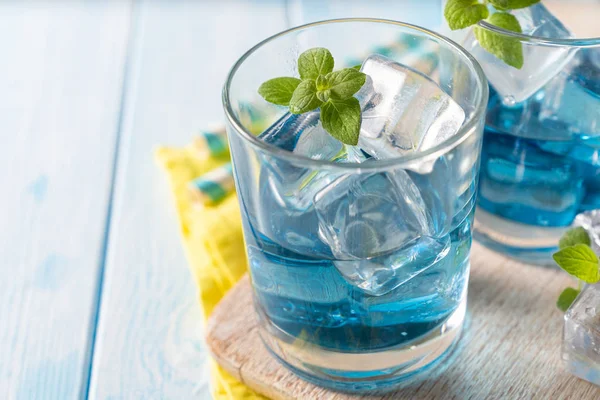 Голубой лимонад в очках на деревянном фоне — стоковое фото