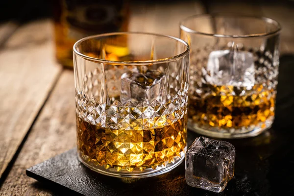 Whiskey em óculos sobre fundo de madeira — Fotografia de Stock