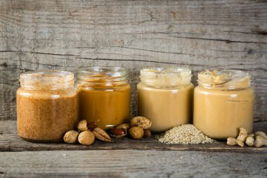 Selection of nut butters - peanut, cashew, almond and sesame seeds clipart