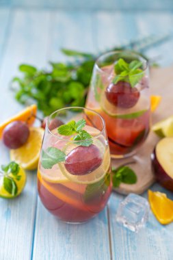 Sangria and ingredients on blue wood background