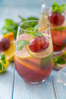 Sangria and ingredients on blue wood background