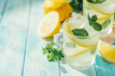 Lemonade and ingredients on blue wood background