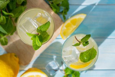 Lemonade and ingredients on blue wood background