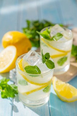 Lemonade and ingredients on blue wood background