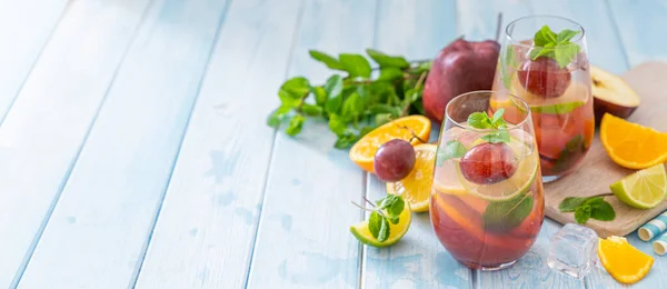 Sangria e ingredientes sobre fundo de madeira azul — Fotografia de Stock