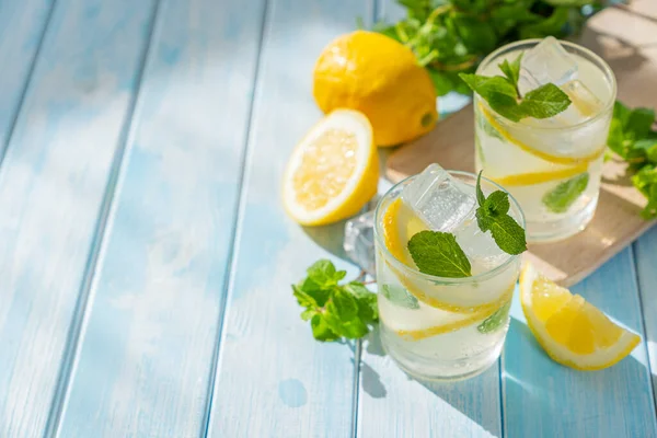 Lemonade and ingredients on blue wood background — 스톡 사진