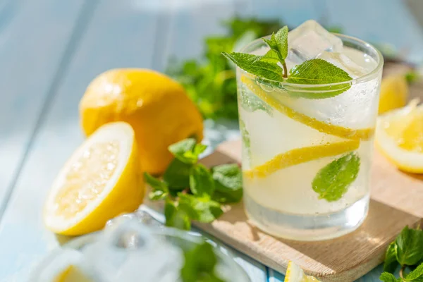 Lemonade and ingredients on blue wood background — Stok fotoğraf