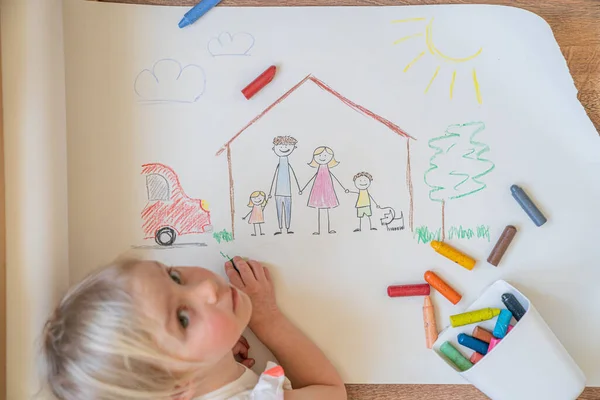 Kids drawing happy family inside the house