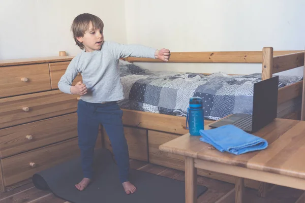 Хлопчик робить онлайн йогу в своїй спальні — стокове фото