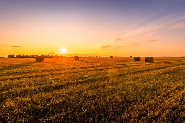 Solnedgångsscenen på fältet med höstack under höstsäsongen. — Stockfoto