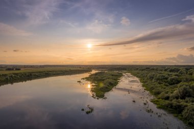Aerial view to sunset on the river at summer evening with cloudy sky. clipart