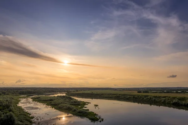 Letecký pohled na západ slunce na řece v letním večeru s oblačnou oblohou. — Stock fotografie