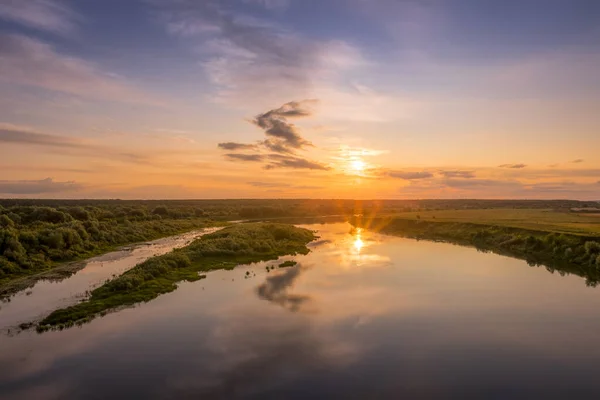 Luftaufnahme zum Sonnenuntergang am Fluss am Sommerabend mit bewölktem Himmel. — Stockfoto