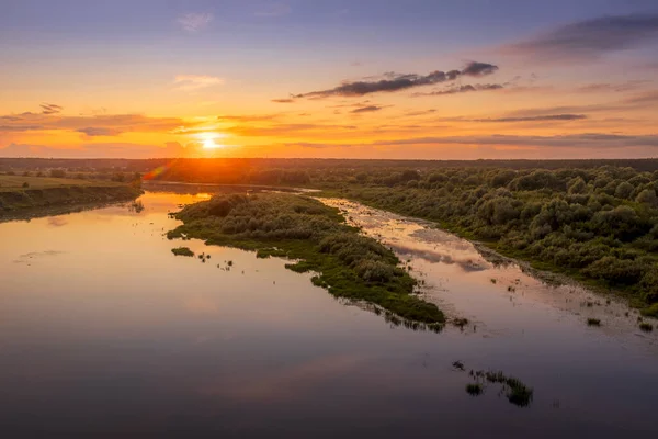 Luftaufnahme zum Sonnenuntergang am Fluss am Sommerabend mit bewölktem Himmel. — Stockfoto