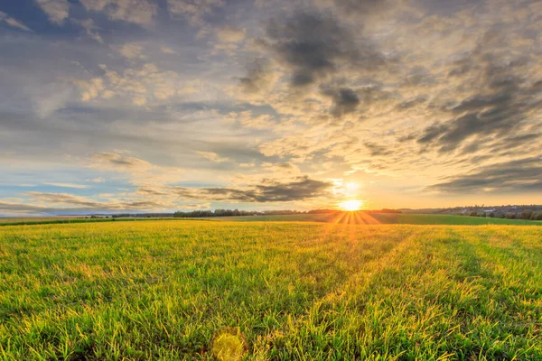 Pôr do sol em terras cultivadas no campo em um verão . — Fotografia de Stock