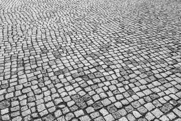 Top view on paving stone road. Old pavement of granite texture. Street cobblestone sidewalk. Abstract background for design.