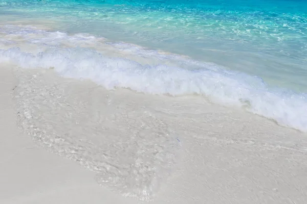 Mořský příboj na pláži s korálovým pískem. — Stock fotografie