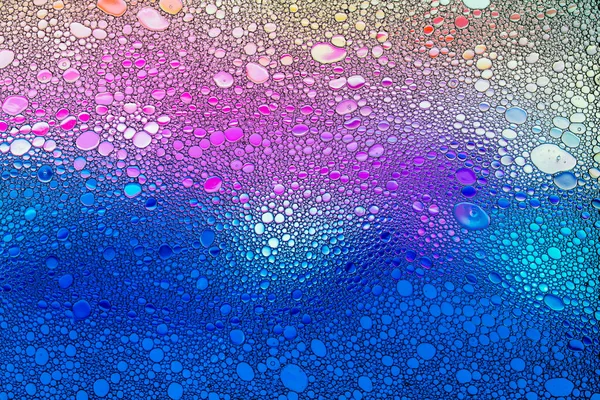 Colorful drops of oil on the water.