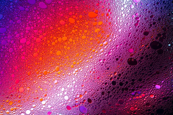 Kleurrijke druppels olie op het water. — Stockfoto