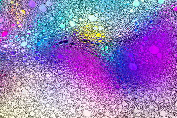 Regenboog kleur druppels olie op het water. — Stockfoto