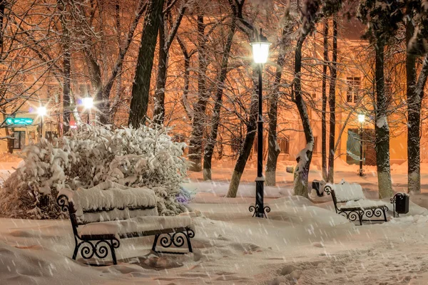 Bänk i vinterparken på natten. — Stockfoto