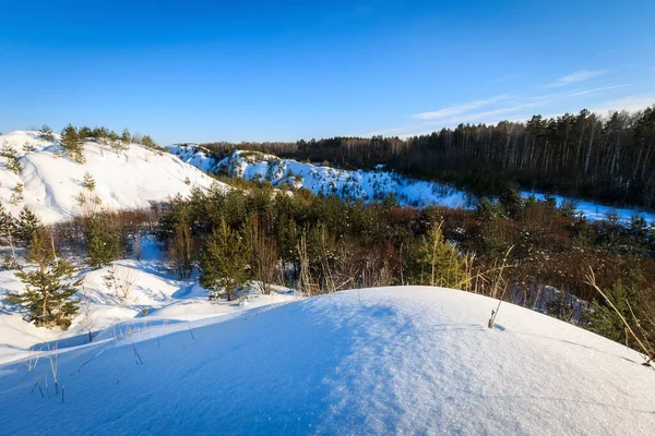 Colinas cobertas de neve no inverno com pinheiros em primeiro plano . — Fotografia de Stock