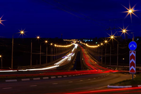 都市を通って光ぼかしと走行中の車 — ストック写真