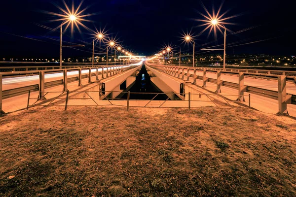 Pohybující se auto s rozmazaným světlem přes město v noci. — Stock fotografie