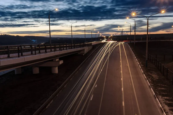 Переміщення автомобіля з розмитим світлом через сутінкове місто. Нічний пейзаж . — стокове фото
