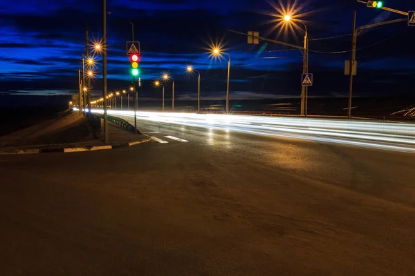 Переміщення автомобіля з розмитим світлом через сутінкове місто. Нічний пейзаж . — стокове фото