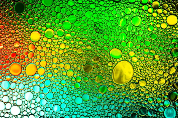 Kleurrijke druppels olie op het water. Gekleurde cirkels en ovalen. Ab — Stockfoto
